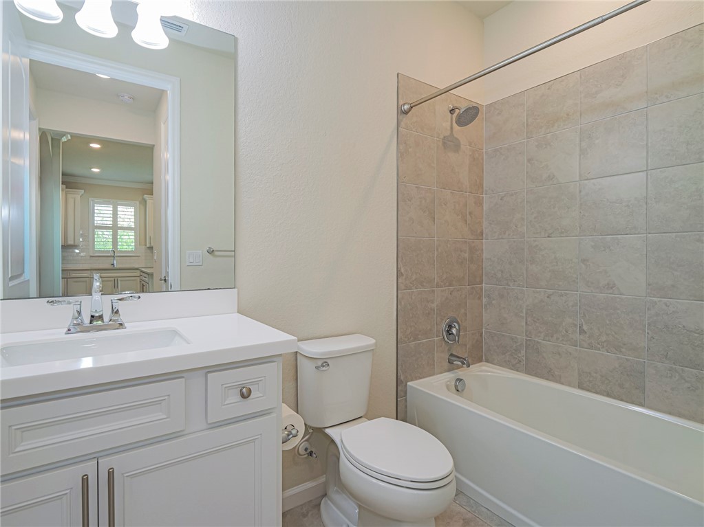 5190 Unity Square Vero Beach, FL 32967 - Photo 23 of 31 a bathroom with a sink a toilet a mirror a bathtub and shower