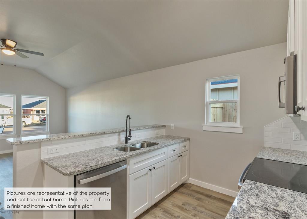 251 Tombstone Road Abilene, TX 79602 - Photo 11 of 27 a kitchen with a sink a stove and cabinets