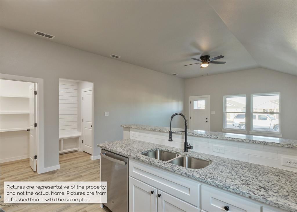 251 Tombstone Road Abilene, TX 79602 - Photo 10 of 27 a kitchen with a sink and a refrigerator