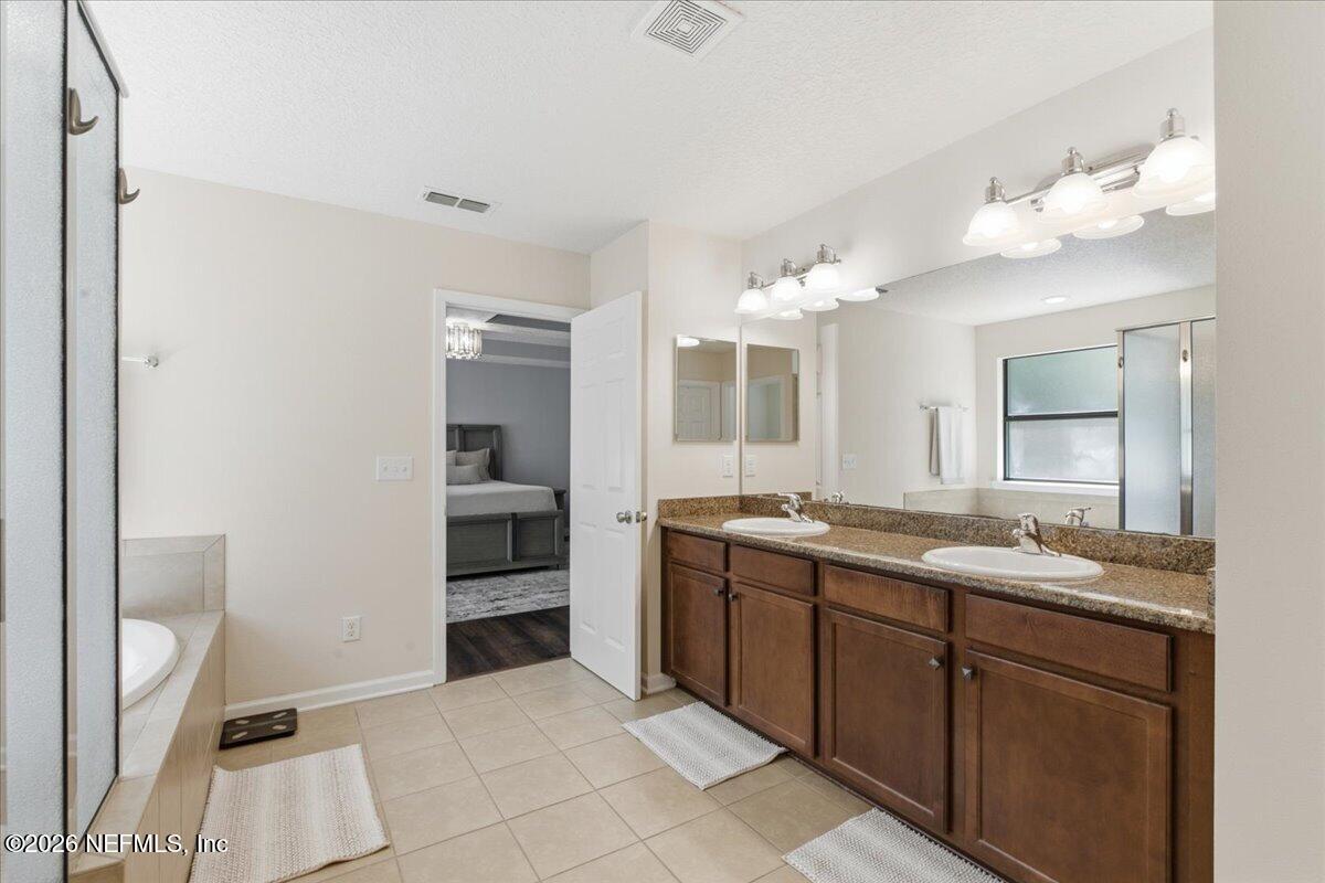 788 Reflection Cove Road East Jacksonville, FL 32218 - Photo 16 of 27 a spacious bathroom with a granite countertop double vanity sink and a mirror