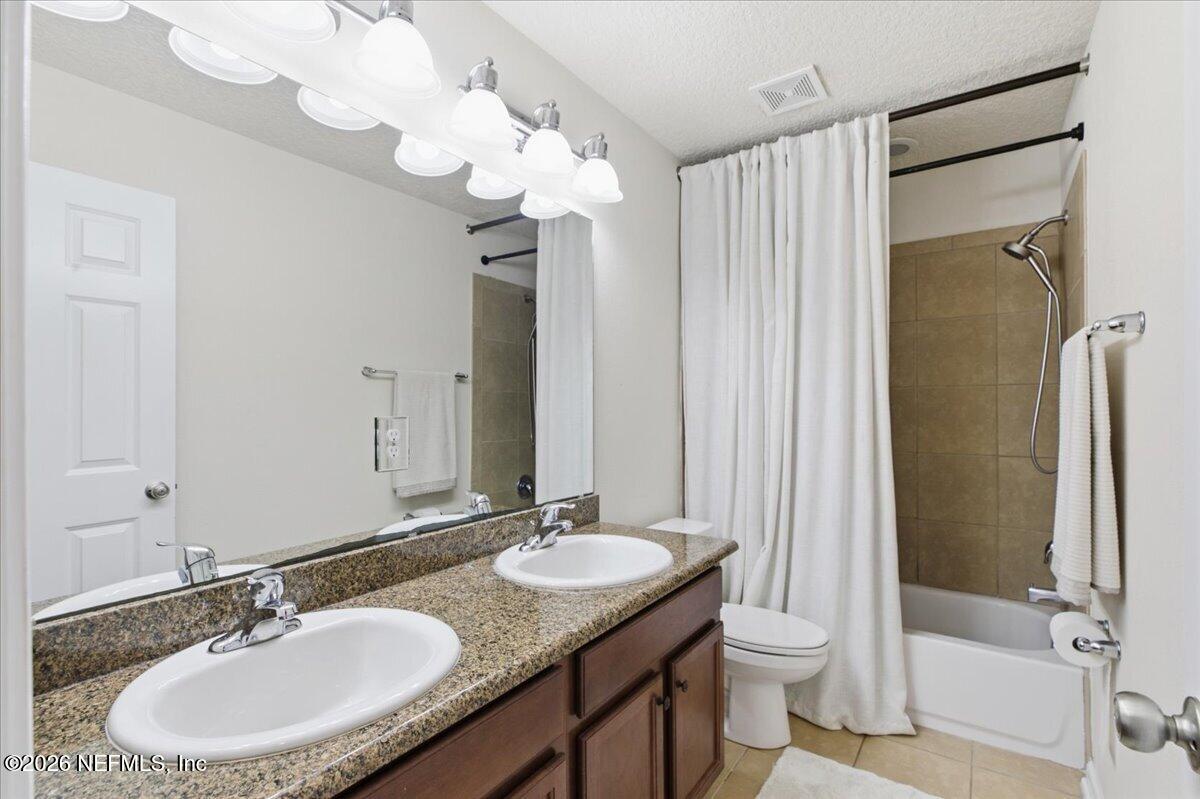 788 Reflection Cove Road East Jacksonville, FL 32218 - Photo 19 of 27 a bathroom with a granite countertop sink a toilet and a mirror