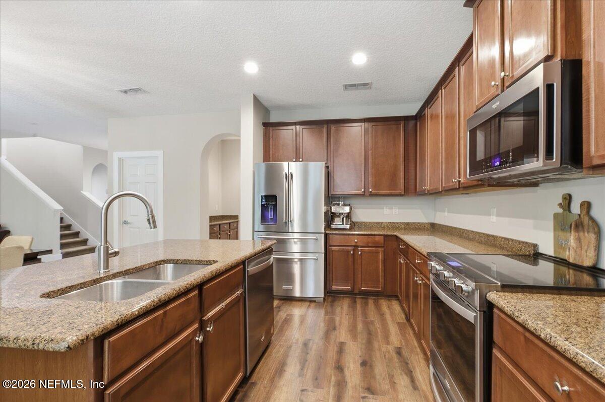 788 Reflection Cove Road East Jacksonville, FL 32218 - Photo 10 of 27 a kitchen with stainless steel appliances granite countertop a sink stove and refrigerator