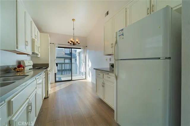a kitchen with refrigerator cabinets and wooden floor