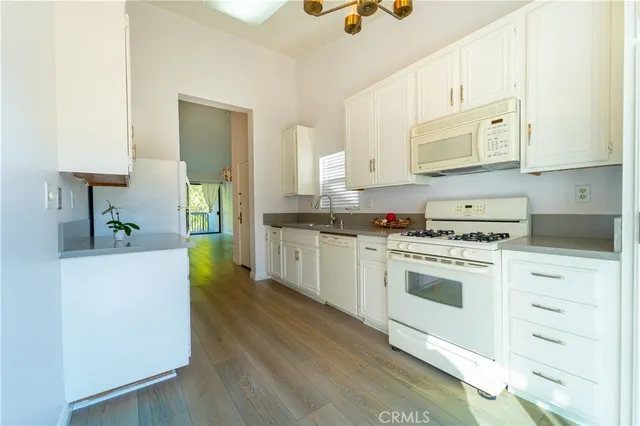 a kitchen with granite countertop a stove a sink and a refrigerator