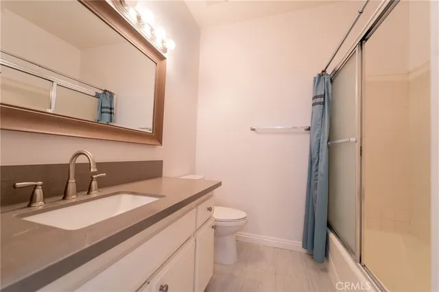 a bathroom with a sink toilet vanity and shower