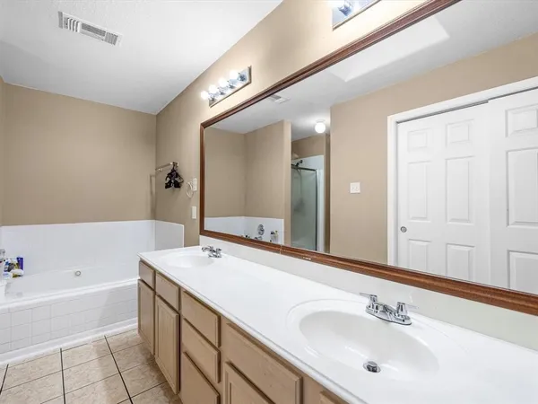 a bathroom with a tub sink and mirror