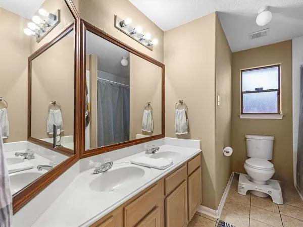 a bathroom with a granite countertop sink a toilet and a large mirror
