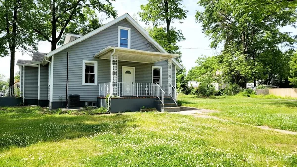 a view of a house with a yard and sitting area