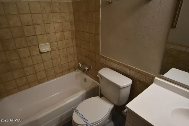 a white toilet and tub sitting next to a bathroom sink