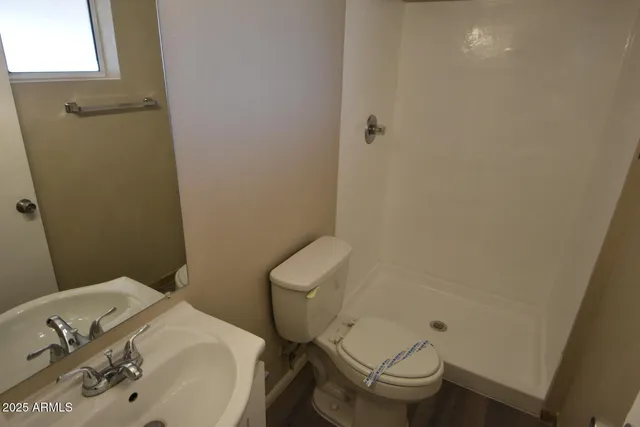 a white toilet sitting next to a bathroom sink and a granite counter top