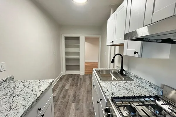 a kitchen with granite countertop a sink stove and cabinets