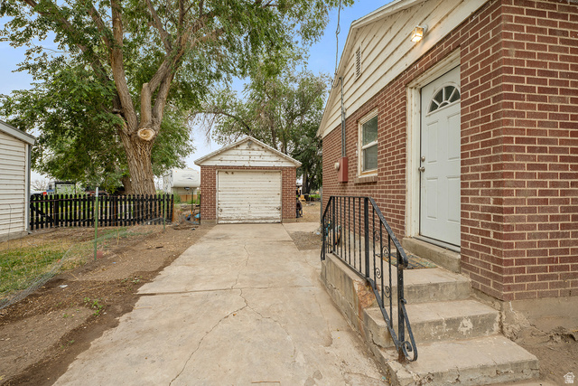 3885 West 4500 S Road Delta, UT 84624 - Photo 23 of 24 Brick exterior with white trim, concrete steps with wrought iron railing, and a white entry door with an arched window detail