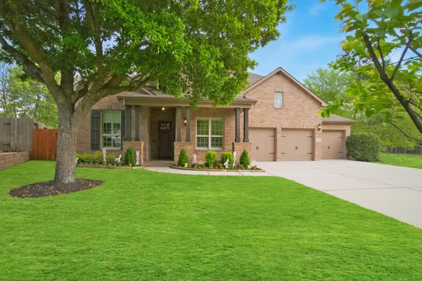 a front view of a house with a garden and yard