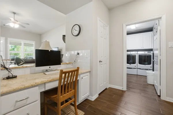 a kitchen with stainless steel appliances kitchen island granite countertop a stove a refrigerator a sink dishwasher and a dining table with wooden floor