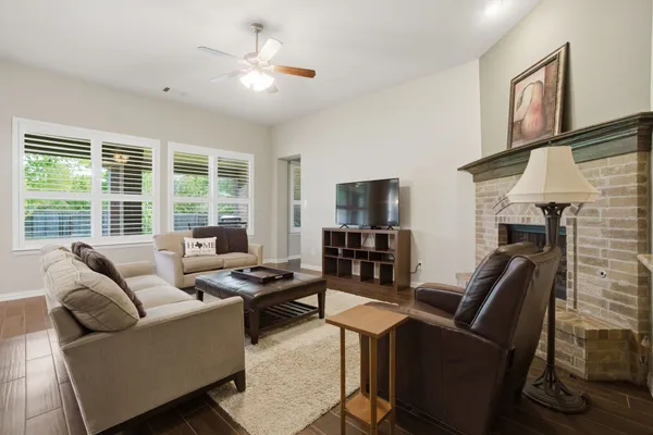 a kitchen with granite countertop a stove top oven a sink dishwasher a dining table and chairs with wooden floor