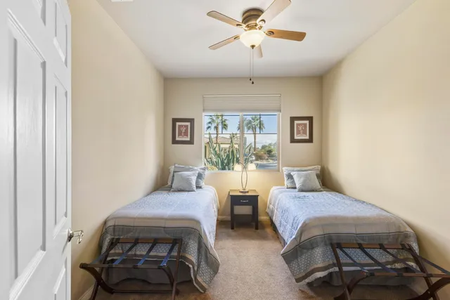 a bedroom with a bed a chandelier and a window