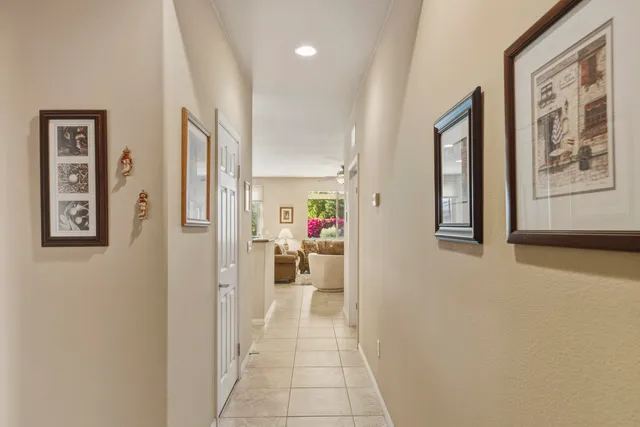 a view of a hallway with wooden floor and living room