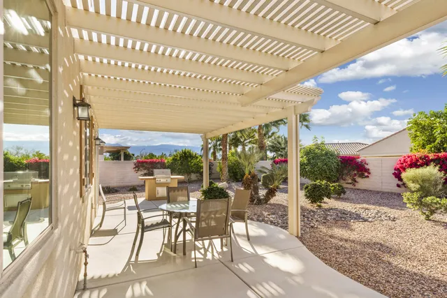 a view of a patio with dining table and chairs