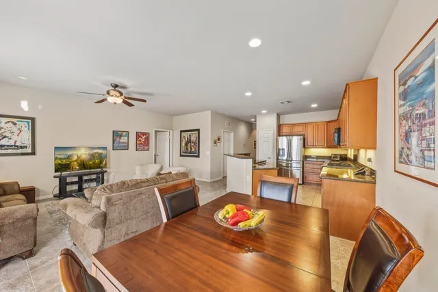 a living room with furniture kitchen view and a large window