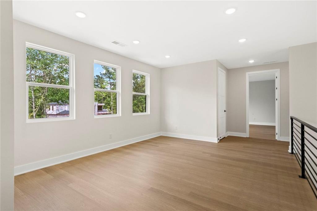 7066 Bells Way Fairburn, GA 30213 - Photo 48 of 64 an empty room with wooden floor and windows