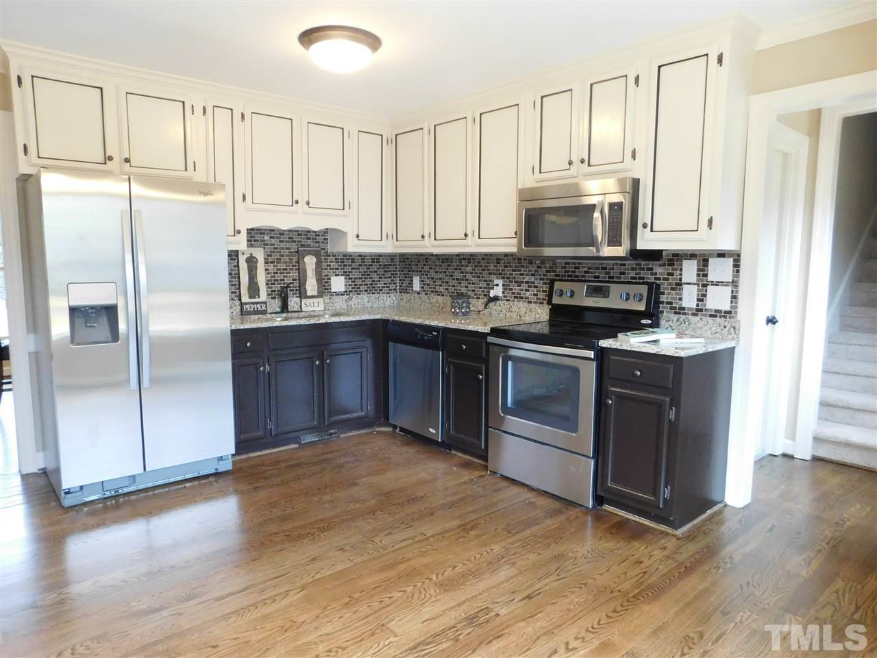 1608 Spennymore Road Raleigh, NC 27603 - Photo 11 of 25 a kitchen with stainless steel appliances granite countertop a stove a sink and a refrigerator