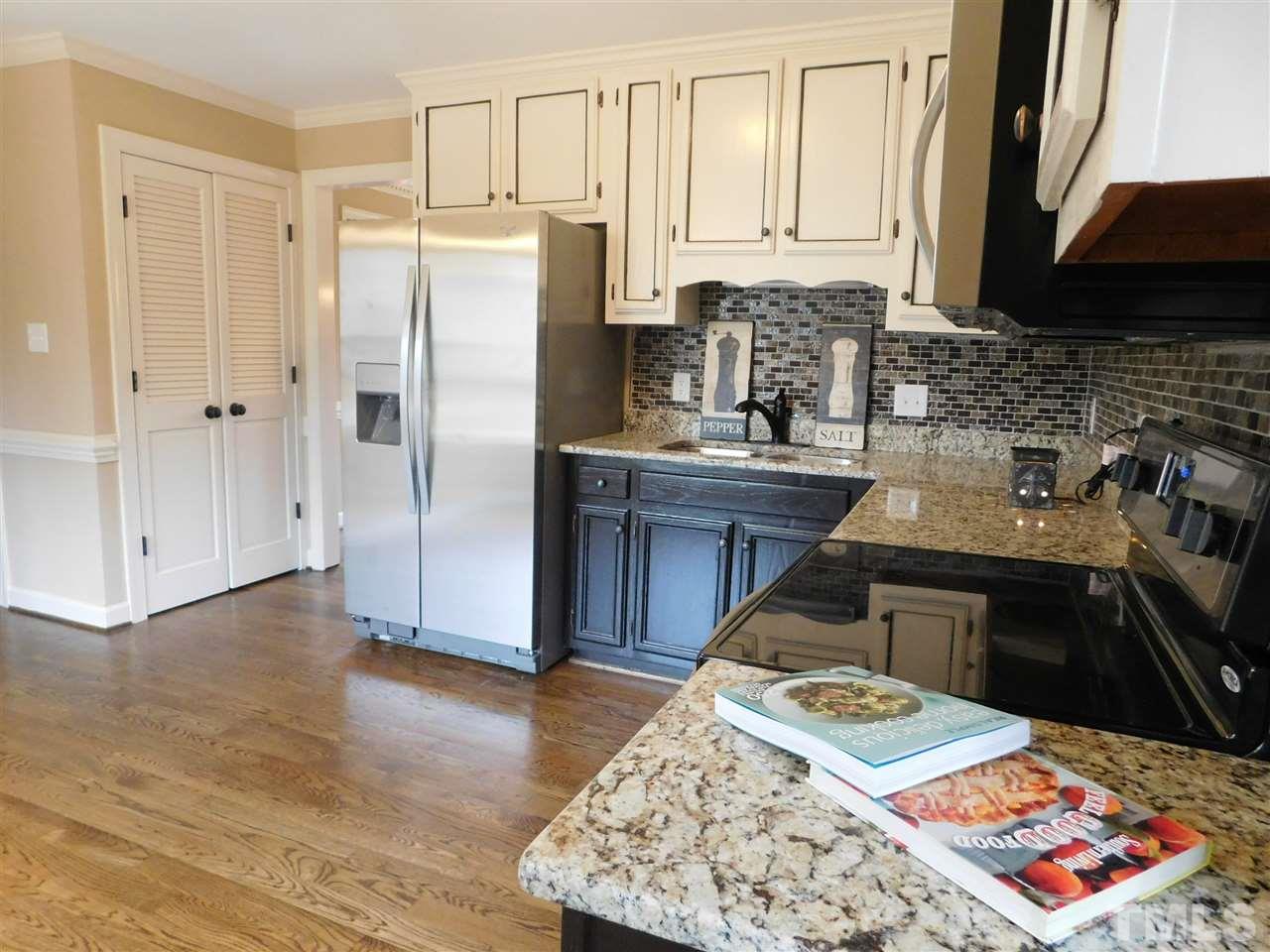 1608 Spennymore Road Raleigh, NC 27603 - Photo 12 of 25 a kitchen with kitchen island granite countertop a sink stove and refrigerator