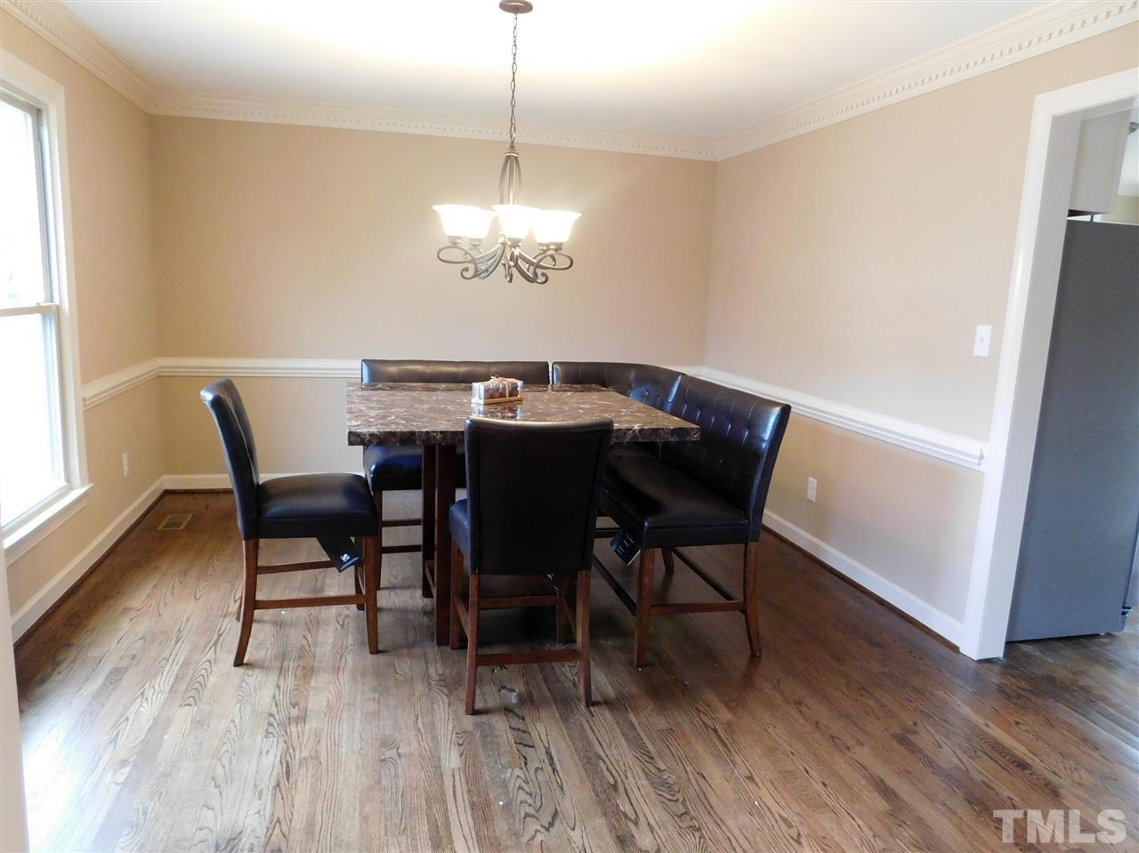 1608 Spennymore Road Raleigh, NC 27603 - Photo 18 of 25 a view of a dining room with furniture wooden floor and chandelier