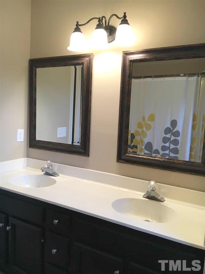 1608 Spennymore Road Raleigh, NC 27603 - Photo 21 of 25 a bathroom with a sink and a mirror