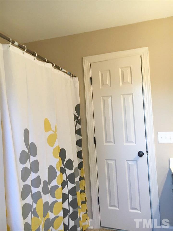 1608 Spennymore Road Raleigh, NC 27603 - Photo 22 of 25 a bathroom with a shower curtain and a sink