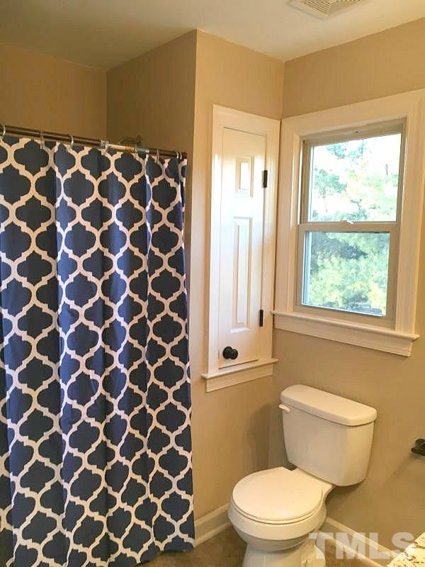 1608 Spennymore Road Raleigh, NC 27603 - Photo 9 of 25 a bathroom with a toilet and a shower curtain
