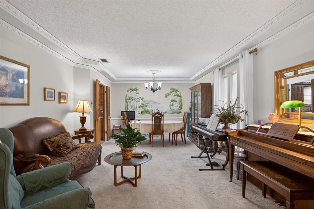 6010 Hunters View Lane Dallas, TX 75232 - Photo 7 of 28 Spacious living area featuring light-toned carpeting, decorative crown molding, and a tray ceiling