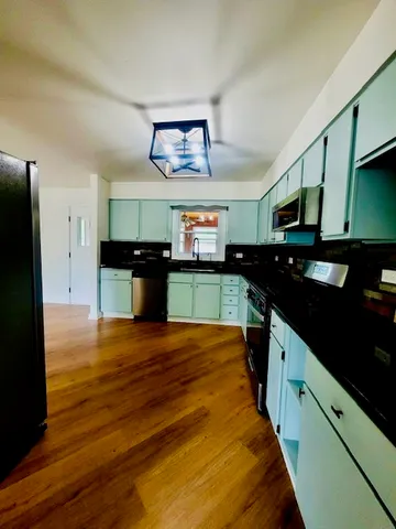 a kitchen with stainless steel appliances granite countertop a stove a sink and a refrigerator