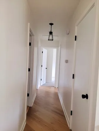 a view of a hallway with wooden floor