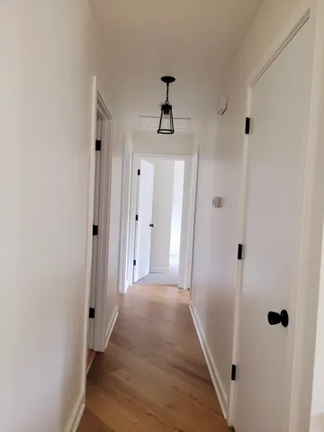a view of a hallway with wooden floor