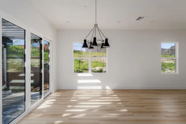 a kitchen with stainless steel appliances kitchen island granite countertop a refrigerator a sink dishwasher a stove and white cabinets with wooden floor