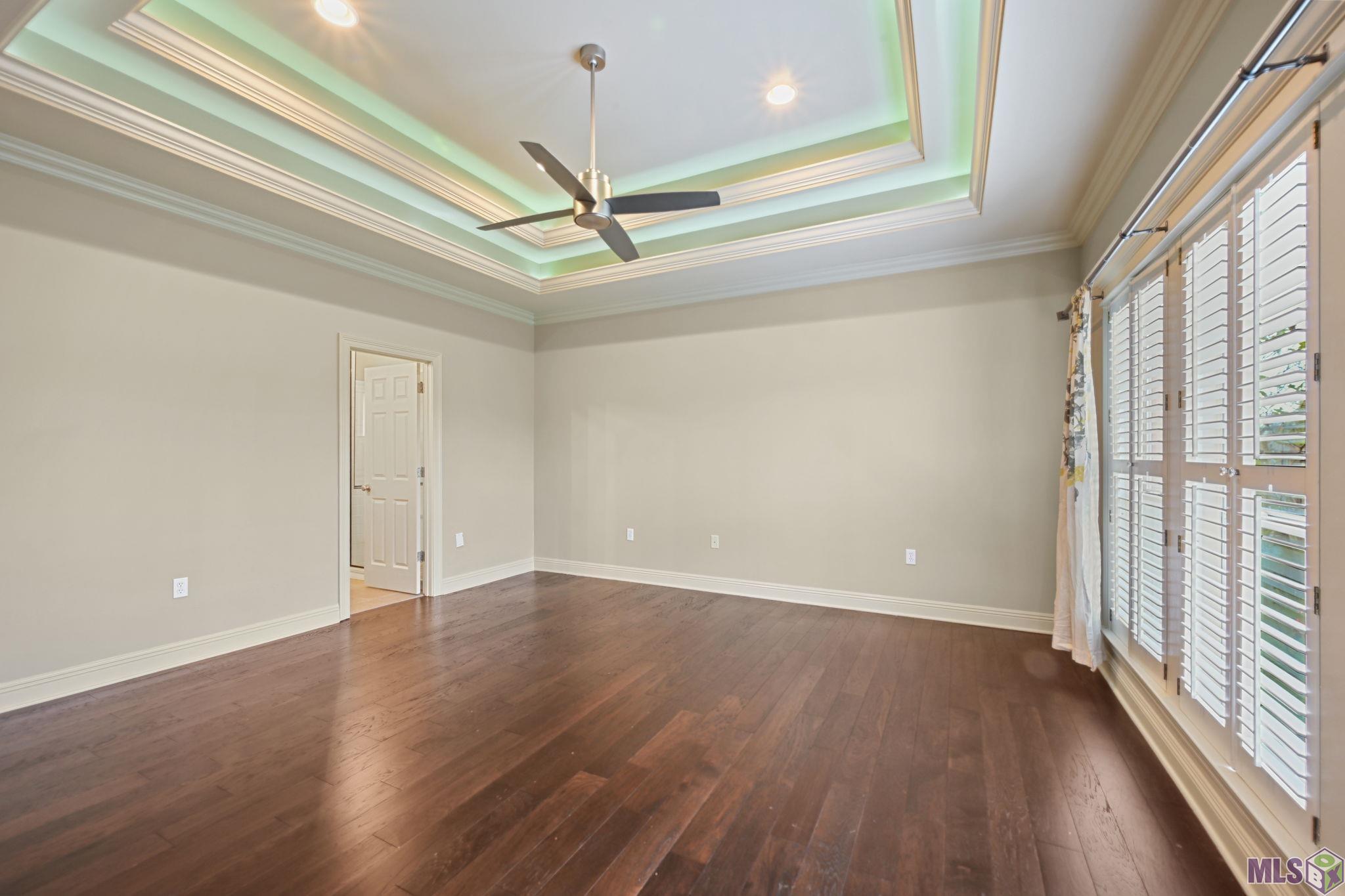 8926 Foxgate Drive St. George, LA 70809 - Photo 11 of 16 PRIMARY W/ LIGHTED TRAY CEILING & WALL OF WINDOWS