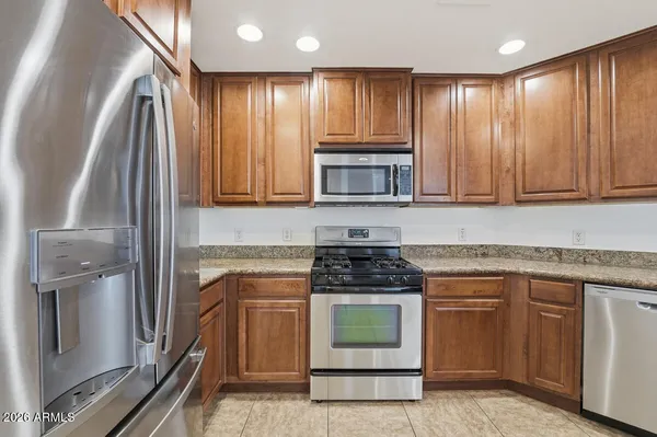 a kitchen with stainless steel appliances granite countertop a stove a sink and a microwave