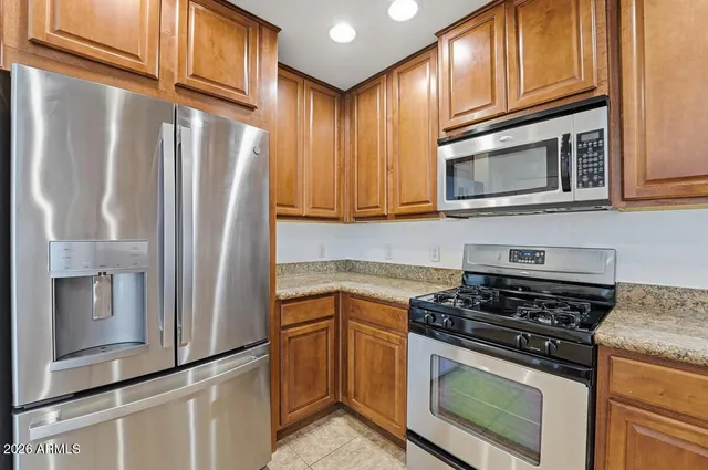 a kitchen with stainless steel appliances granite countertop a refrigerator stove and microwave