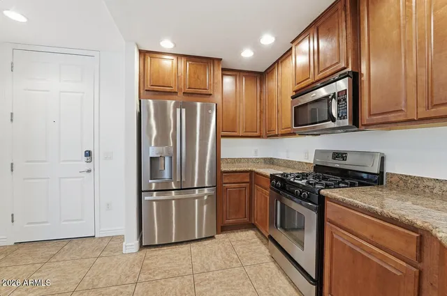 a kitchen with stainless steel appliances granite countertop a refrigerator stove and microwave