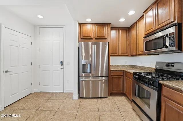a kitchen with granite countertop a refrigerator and a stove top oven