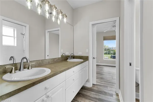 a bathroom with double vanity and a mirror