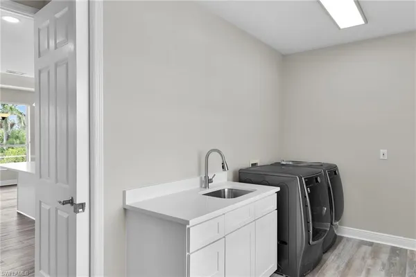 a utility room with sink dryer and washer