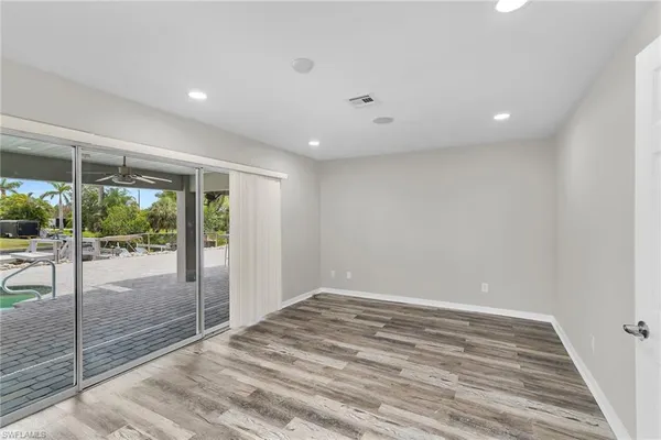 a view of an empty room with wooden floor