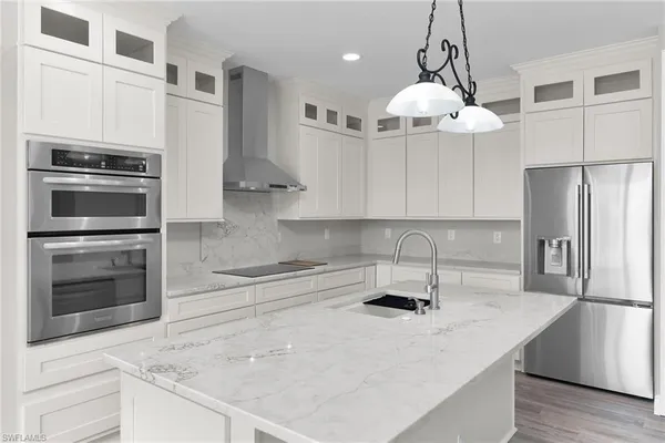 a kitchen with stainless steel appliances granite countertop a sink a stove and a refrigerator