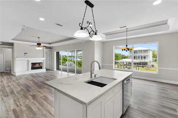 a kitchen with a stove a sink a center island and wooden floor