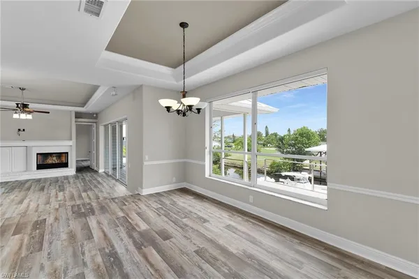 a view of empty room with wooden floor fireplace and window