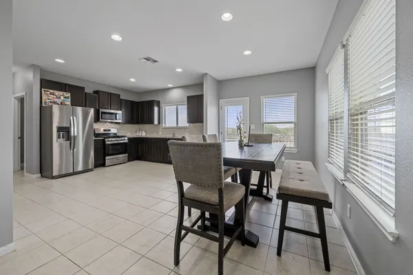a large kitchen with a table and chairs
