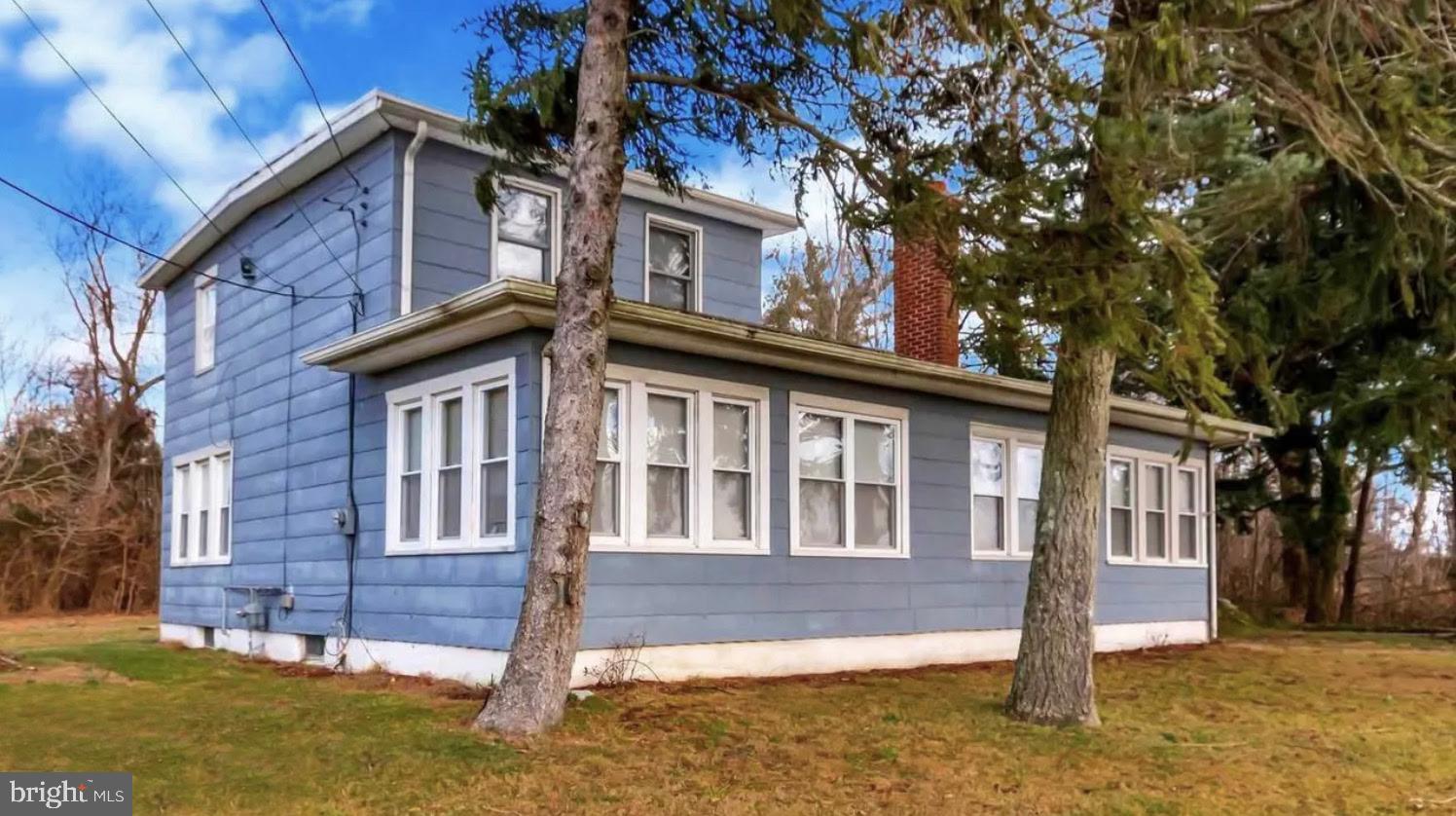 a front view of a house with a tree