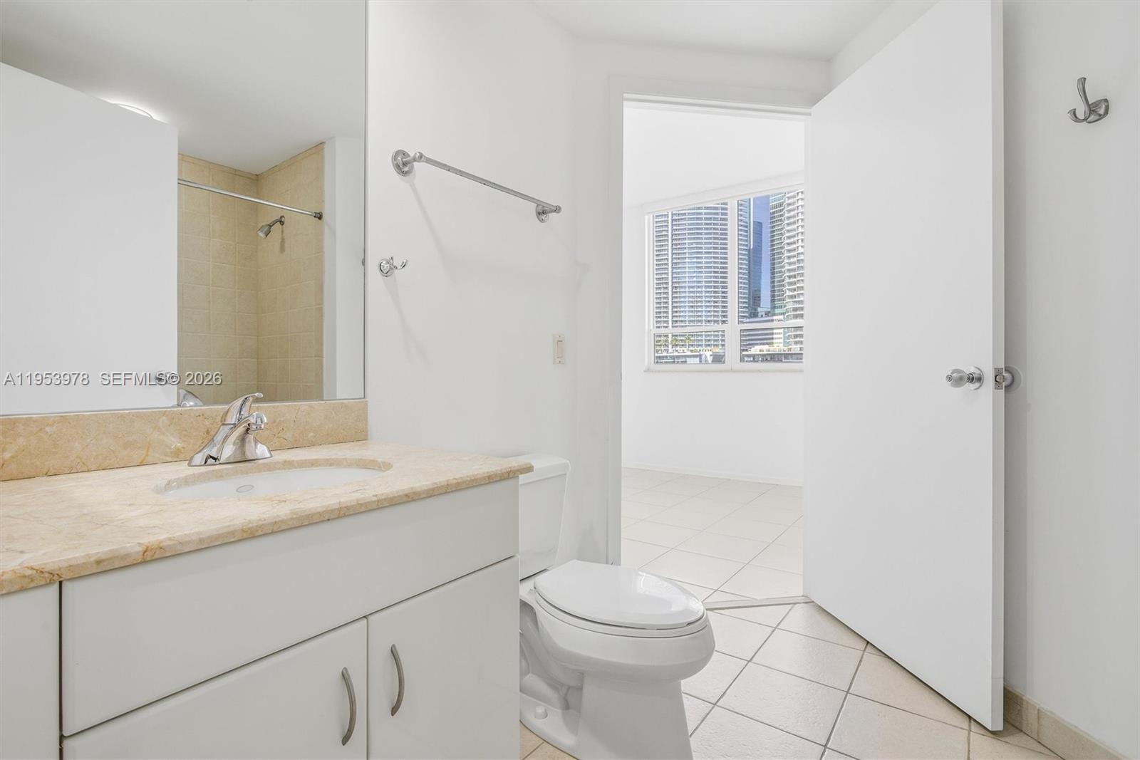 801 Brickell Key Boulevard, Unit 1404 Miami, FL 33131 - Photo 21 of 44 a bathroom with a granite countertop sink toilet a mirror and shower