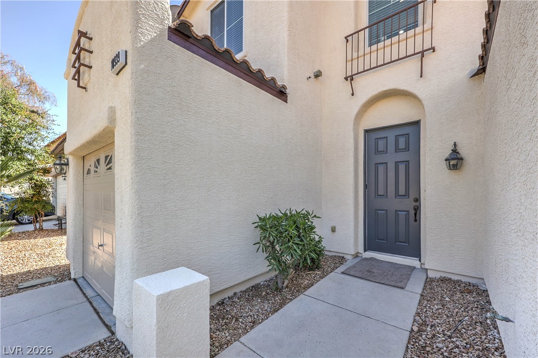 10939 Paradise Road Henderson, NV 89052 - Photo 3 of 36 An inviting entryway welcomes residents with an arched doorway and an attached garage.